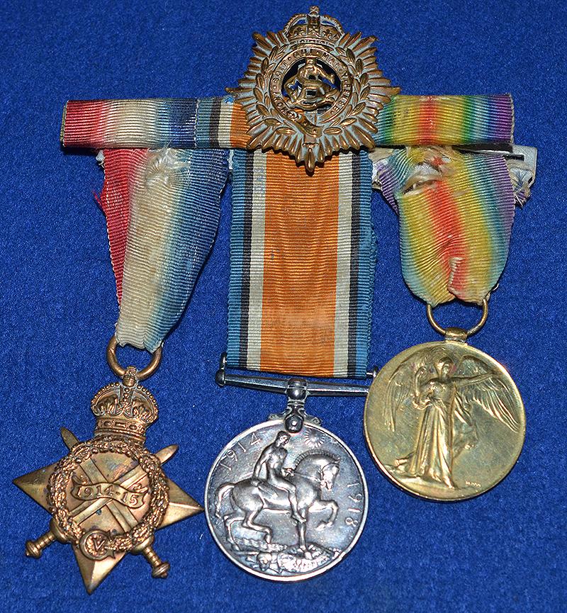 SET OF THREE WW1 BRITISH MEDALS COMPLETE WITH THE OWNERS CAP BADGE.