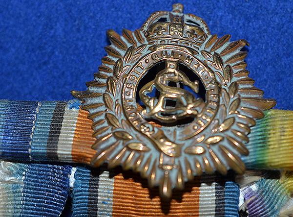SET OF THREE WW1 BRITISH MEDALS COMPLETE WITH THE OWNERS CAP BADGE.